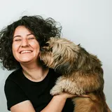 Otis, a shaggy terrier mix, cuddling his person